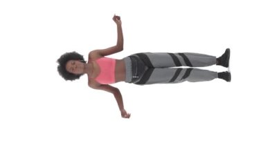 Dikey video. Afrikalı bir kadının hip hop dansı sahnesinin tam önünde. Sokak dansı tarzı konsept. Beyaz arkaplanda izole