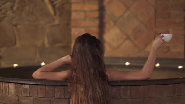 特写镜头 一位年轻女子在温泉浴中喝着香气茶 温泉和健康 模糊的背景 — 图库视频影像