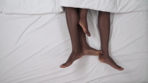 Birbirine Dolanmış Siyah Tenli Erkek Kadın Bacaklarının Beyaz Battaniyeden Dışarı — Stok video