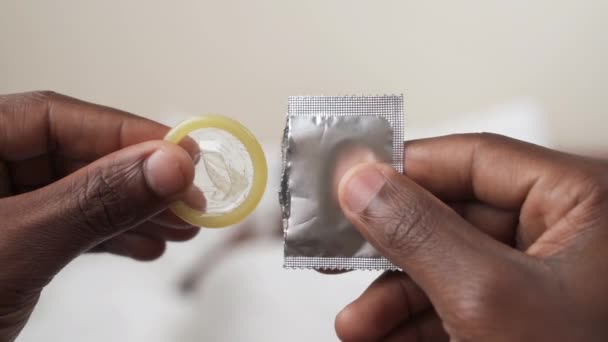 Concentra Nas Mãos Homem Negro Desempacotar Preservativo Fundo Deitado Cama — Vídeo de Stock