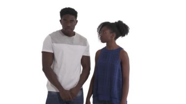 Genç Afrikalı bir çiftin portresi. Aptal adam kameraya bakıyor. Kızgın kız arkadaşı kafasına tokat atıyor. Beyaz arkaplanda izole