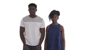 Şaşırmış Afrikalı bir çiftin portresi, beyaz arka planda izole edilmiş büyük bir sürprizle ellerini yüzlerine kaldırıyor ve ağızlarını açıyor.