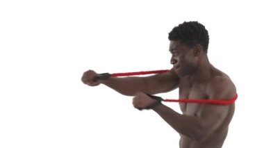Üstsüz Afrikalı dövüşçülerin direniş bandı kemeriyle yumruk çalışmalarının yan görüntüsü. Profesyonel spor konsepti. Beyaz arkaplanda izole