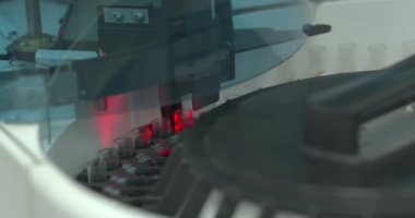 Otomatik analiz cihazında dönen sarı sıvıyla dolu test tüpleri. Modern laboratuvar analiz yöntemleri. İdrar testi. Sağlık hizmetleri kavramı