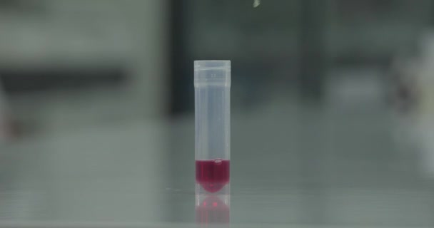 试管中的颜色变化反应 实验室助理用吸盘搅拌液体 红色样品变成黄色 卫生保健概念 模糊的背景 — 图库视频影像
