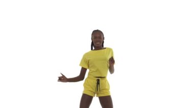 Dans eden Afrikalı kadın tüm vücuduyla dönüşümlü hareketler yapıyor, ellerini kaldırıyor, arkasını dönüp kalçalarını çeviriyor. Beyaz arkaplanda izole.