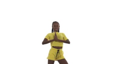 Genç Afrikalı kadın dans ediyor, elleriyle farklı hareketler gösteriyor, kalçalarını oynatıyor. Sokak dansı. Beyaz arkaplanda izole.