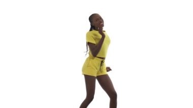 Afro tarzı dans eden Afrikalı kadın. Dansçı salıncak adımları atıyor, biraz zıplıyor ve güçlü bir şekilde sallanıyor. Beyaz arkaplanda izole.