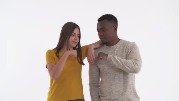 友好的跨种族夫妇给予拳头一击 问候和认可的手势 因白人背景而被隔离 — 图库视频影像