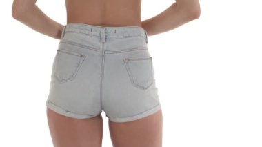 Tanımlanamayan beyaz bir kadının kalçasından kot şort çıkarması. Model kıyafetleri. Beyaz arkaplanda izole.