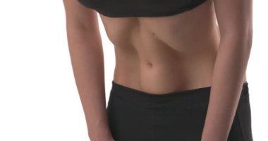 Genç fitness beyaz kadın mide vakumu egzersizi yapıyor. Karın kaslarıyla dalgalar yaratıyor. Nauli Kriya yoga masajı. Kapatın. Beyaz arkaplanda izole.