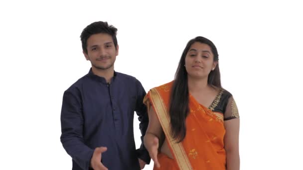 若いインド人夫婦は誰か見えない人と握手をする 挨拶のジェスチャー 白地に隔離された — ストック動画