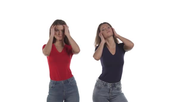 性感的白人孪生姐妹在镜头前摆姿势 用手指梳理头发 因白人背景而被隔离 — 图库视频影像
