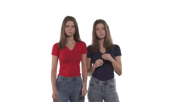 白种人孪生姐妹的画像表现出暂停的姿态 使T形的手 因白人背景而被隔离 — 图库视频影像