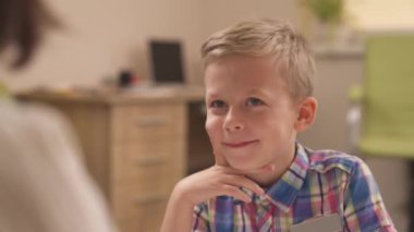 Küçük çocuğun, tematik algılama testini (TAT) geçerken bir terapiste resmi tarif ederken çekilmiş yakın plan portresi. Projektif psikolojik test konsepti.