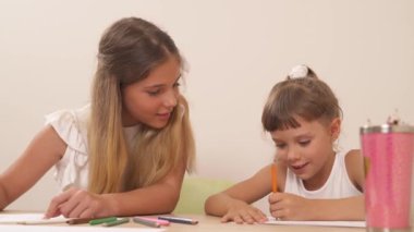 Psikolojik seans sırasında çizim yaparken kız kardeşiyle konuşan ergen bir kız. Aile psikolojisi