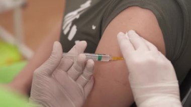Doktor hastane odasında iğne yapıyor ve enjeksiyondan sonra hastanın koluna alçı yapıştırıyor. sağlık hizmeti kavramı