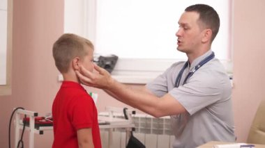 Servikal ve infraclavicular lenf düğümlerini kontrol eden çocuk doktoruna yakın çekim. Küçük çocuk doktoru ziyaret ediyor.