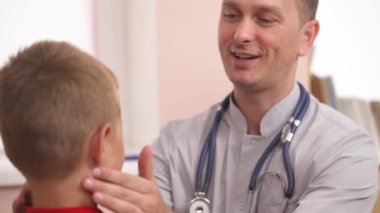 Sofistike otolaringolojistlerin en alttaki fotoğrafı şişmiş lenf düğümlerini küçük bir çocuk için kontrol ediyor. Otolaryngology. Sağlık sigortası konsepti. Seçici odak atışı