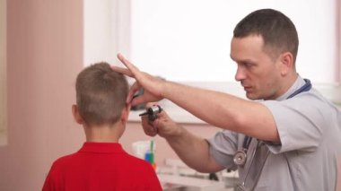 Hastanede küçük hastaların kulaklarını kontrol etmek için otoskop kullanan bir doktor. Otolaryngology. Sağlık hizmetleri kavramı.