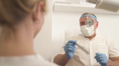 Profesyonel otolarolog, kadın hastasının boğazını inceliyor. Sağlık kontrolünden. Seçici odak atışı