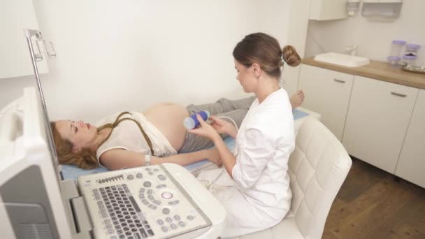 超音波検査を受けた妊婦さんの高い角度からの眺め 超音波プローブをソノグラフィックゲルで保持する医師 超音波検査による医療検査 — ストック動画