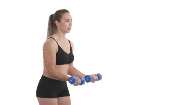 一个女运动员用哑铃做二头肌训练的侧视图 因白人背景而被隔离 — 图库视频影像