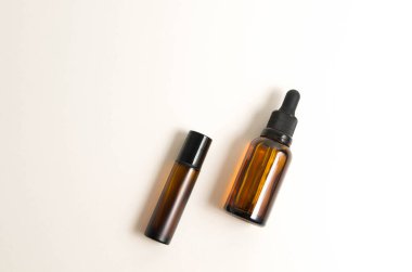 Beyaz arka planda pipeti olan boş kehribar cam esaslı yağ (serum) şişesi. Doğal kozmetik ile cilt bakımı kavramı.