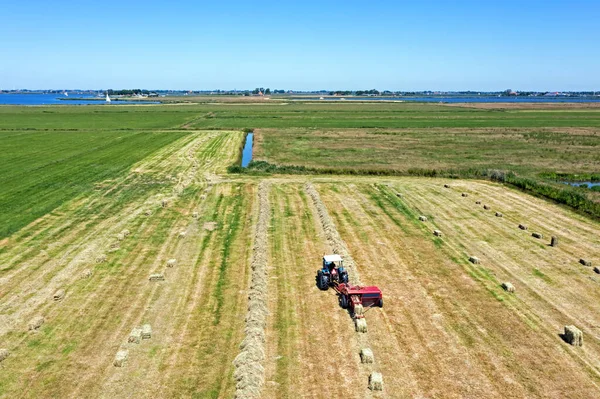オランダのフリースラントから田舎で干し草を収穫することからの空中 — ストック写真