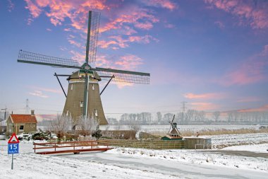 Kırsal kış gün batımında Hollanda'dan tarihi yel değirmeni