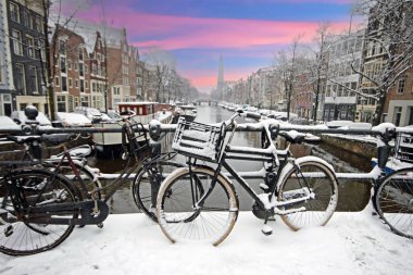 Amsterdam kar Westerkerk ile kışın Hollanda'da günbatımında kaplı