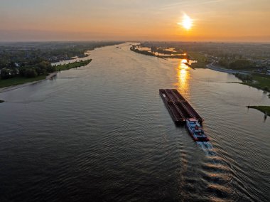 Gün batımında Hollanda 'daki Merwede nehrinden kalkan hava aracı.