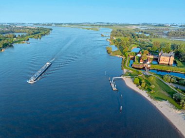 Hollanda 'daki Loevestein şatosuyla Merwede nehrinden kalkan hava aracı.