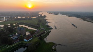 Gün batımında Hollanda 'da Loevestein Şatosu yakınlarındaki Merwede nehrindeki bir kargo gemisinden havadan.
