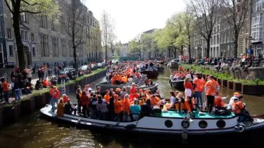 AMSTERDAM, NETHERLANDS - 27 Nisan 2024: Hollanda 'daki Amsterdam kanallarında yerel halk krallar gününü kutluyor