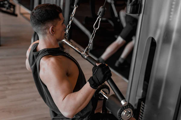 young bodybuilder and personal trainer working out in a modern, well-equipped gym. With determination and focus, the bodybuilder engages in various exercises, showcasing strength and athleticism. The