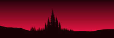 Kırmızı ağaçları ve dağları olan bir tepenin silüeti