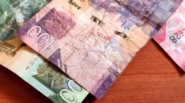 Kenya Bank 'ın yukarı doğru kayan çekim hareketi. Yaklaş, makro. Üst üste yığılmış farklı notlar ve bir bozuk para.