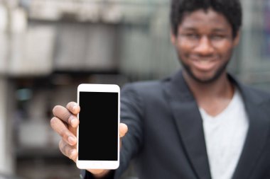 Afrikalı işadamı boş akıllı telefon ekranı gösteriyor