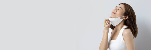 Banner crop of woman finally start taking face mask off in post pandemic world