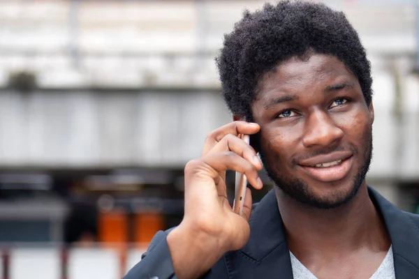 幸せな笑顔アフリカのビジネスマンが話して スマートフォンを介して交渉する — ストック写真