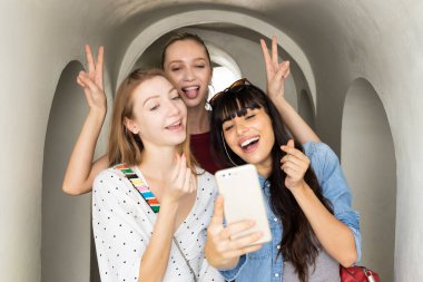 Bir grup mutlu kadın arkadaş selfie çekiyorlar.