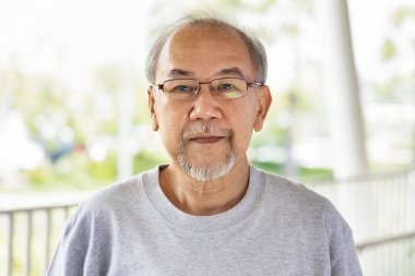 Gri saçlı ve sakallı yaşlı Asyalı adamın portresi.