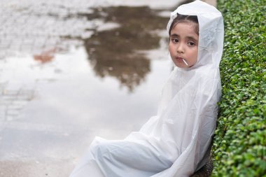 Bored little girl waiting after the rain clipart