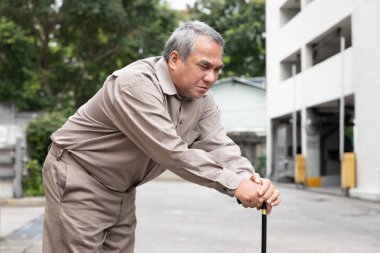 Overweighted fat senior old man suffering from serious late stage of herniated disk or displaced spinal issue walking with walking aid stick clipart