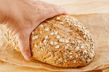 Keten tohumu ve ayçiçeği tohumlarıyla kaplı taze pişmiş tam tahıllı ekmek.