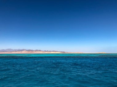 Mısır 'ın muhteşem ufuk çizgisi. panoramik mavi deniz yüzeyine kıyıdan çok uzakta bakar. Doğal arka plan güneşli gün gökyüzü. Boş alan duvar kâğıdı modellemesi. Yaz arkaplanı sakin Deniz Kızıldeniz