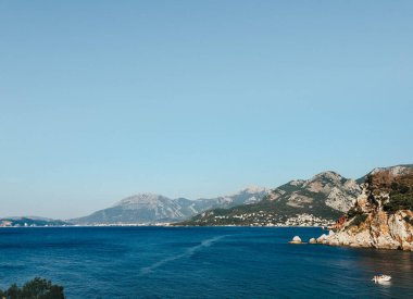 Karadağ Sutomore taşlarının en üst manzarası plaj mavisi turkuaz Adriyatik deniz suyu dağları günü. Karadağ 'ın kayalık kıyı manzarası. Güzel gök mavisi okyanus. Yaz arkaplanı 