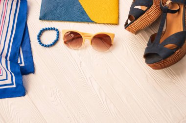 Güneş gözlüğü bijouterie mücevher bilezik el çantası ayakkabı kama. Yaz arkaplanı modeli. Beyaz ahşap arka planda en üstteki manzara yaz moda aksesuarları plajı. Kadınlar yaz tatili konsepti