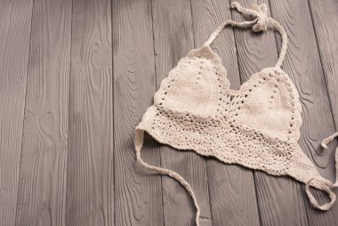 İki parçalı mayo mayo giyen beyaz örülü bir kadın. Moda gözlüğü takıyor. Yaz arkaplan şablonu maket uzay şablonu örnekleme metni. Gri ahşap arkaplanın üstü.